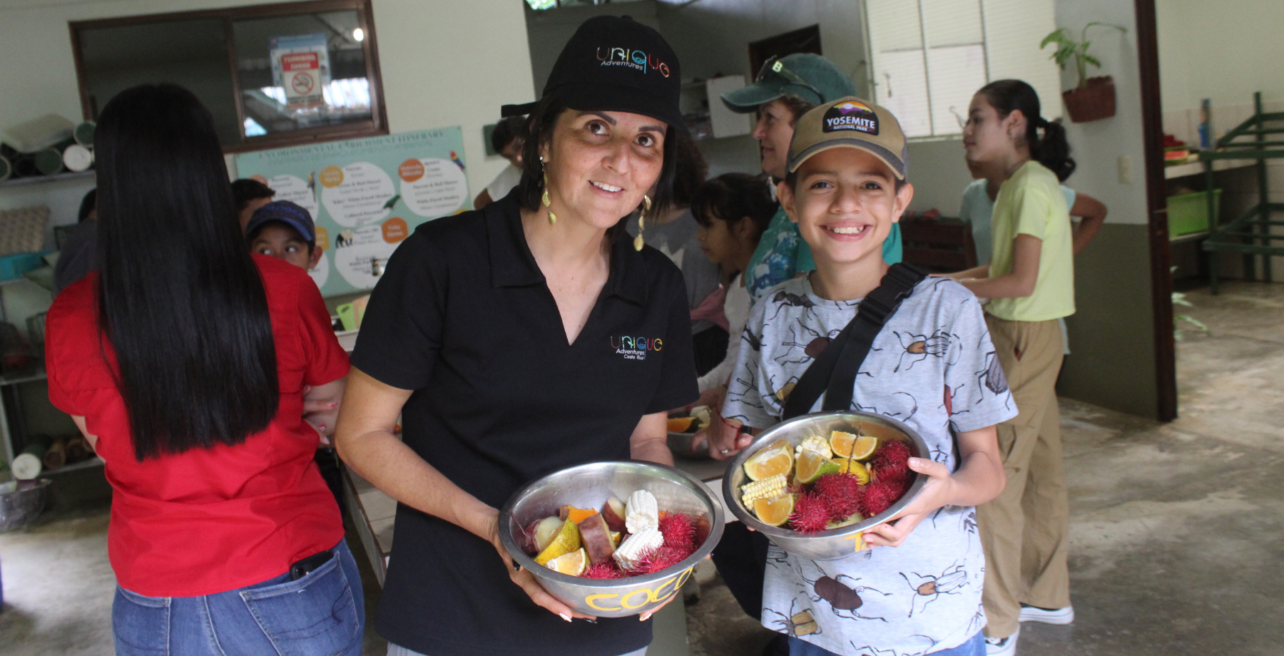 Unique Costa Rica Guide with a student from Group of students from El Cruce School in Costa Rica holding bowls of fruit for wildlife