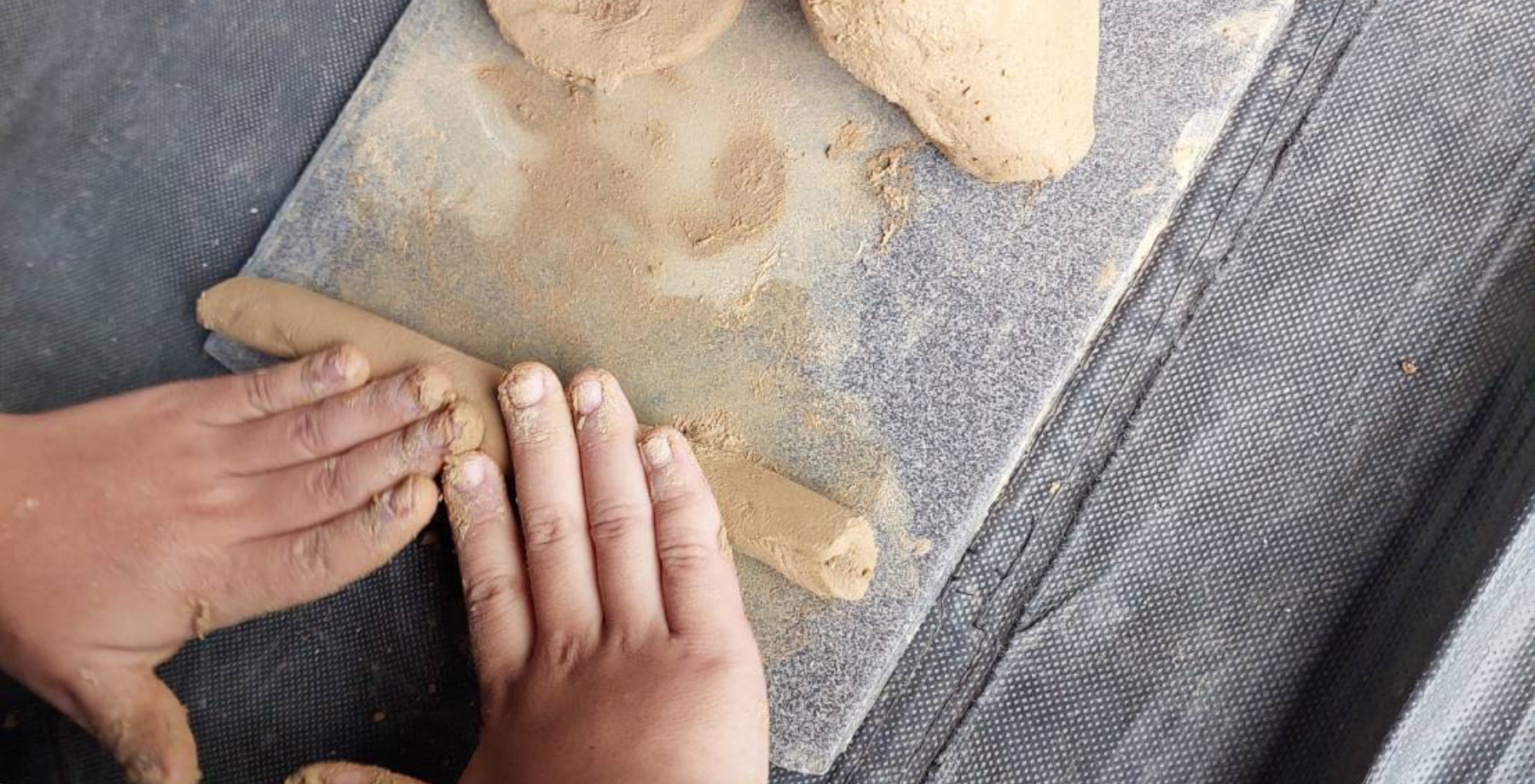 Close up of child's hands making potter on a Buy A Trip, Give A Trip