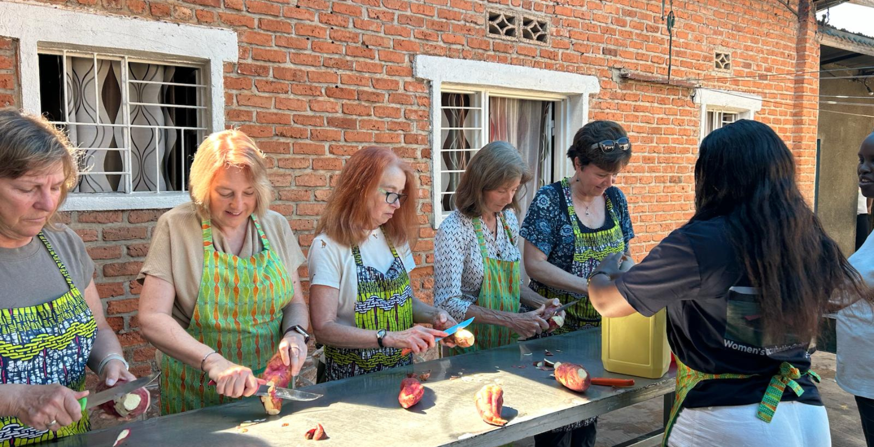 donor trip group cut potatoes together during cooking demonstration.